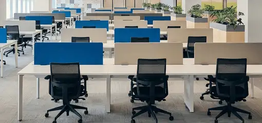 Modern open-plan office space featuring clean workstations, ergonomic chairs, and sanitized carpets provided by professional office cleaning services in Mesa, AZ.